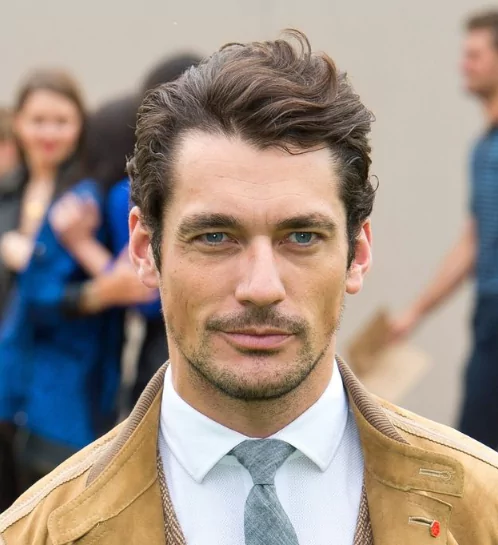 David Gandy: Medium Length Hairstyle With Widow's PeakDavid Gandy wearing a classic medium-length hairstyle, brushed back to reveal his widow’s peak, with added volume and a polished, textured finish.